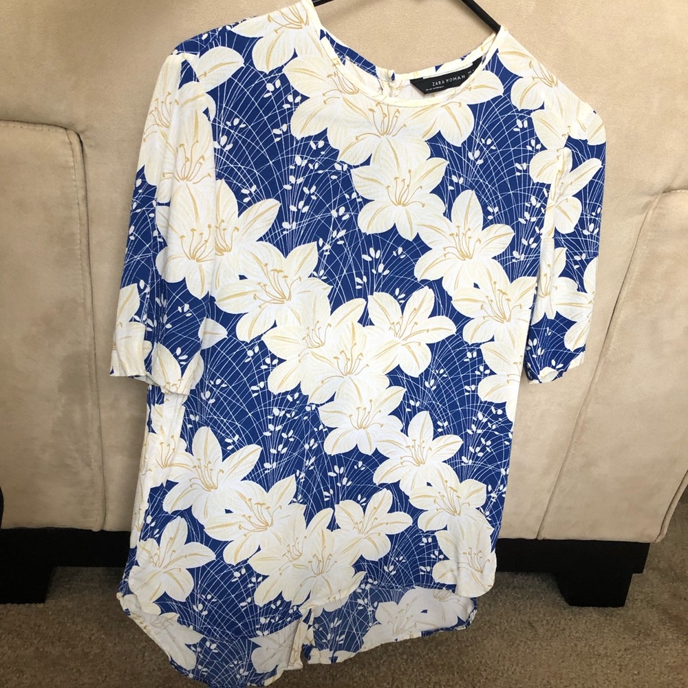 Floral top with sleeves. Buttons in the back